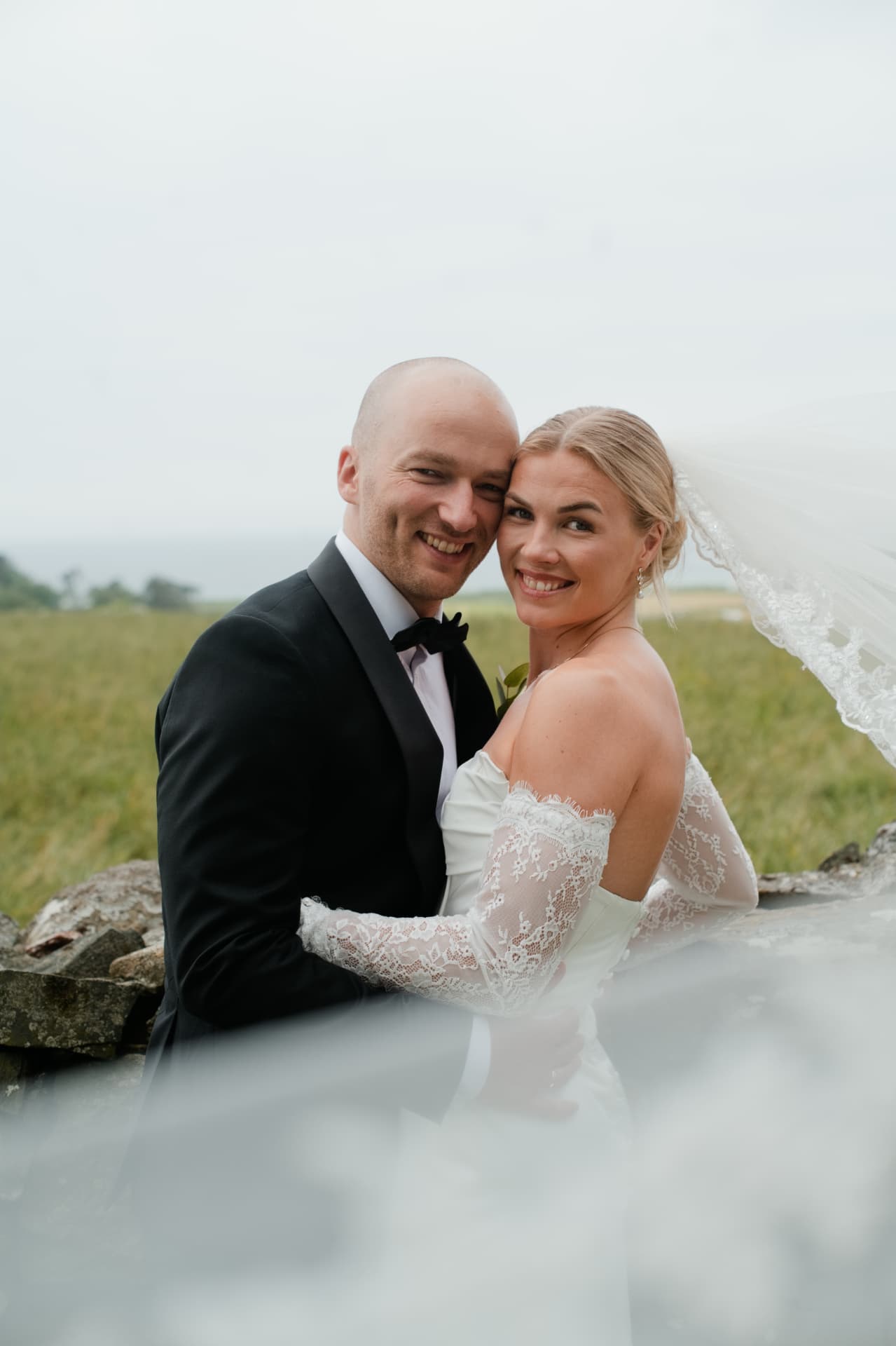Portrait of the couple with the veil catching the wind
