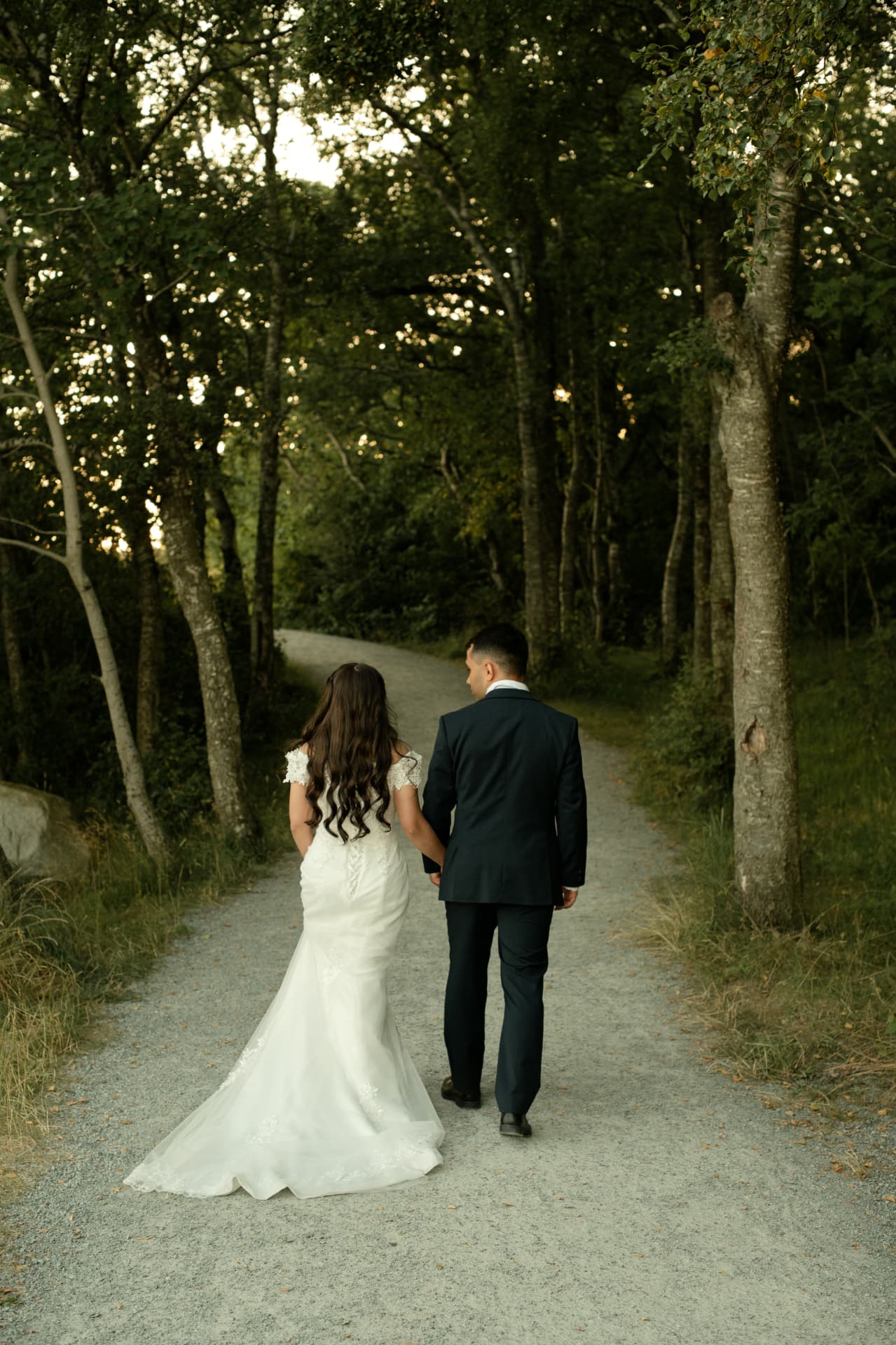 Couple walking a woodland path in the evening light