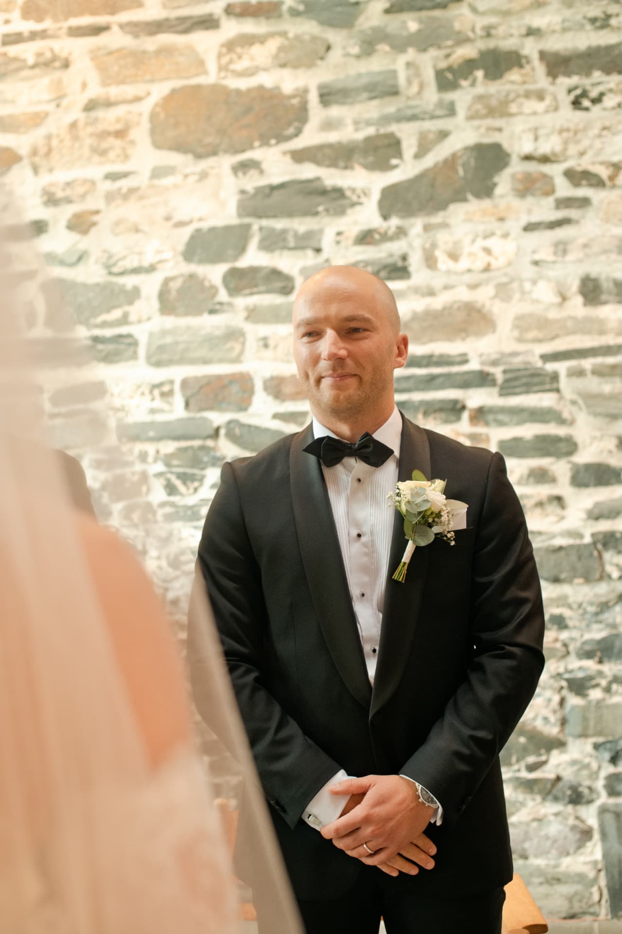 Groom watching his bride arrive at the altar