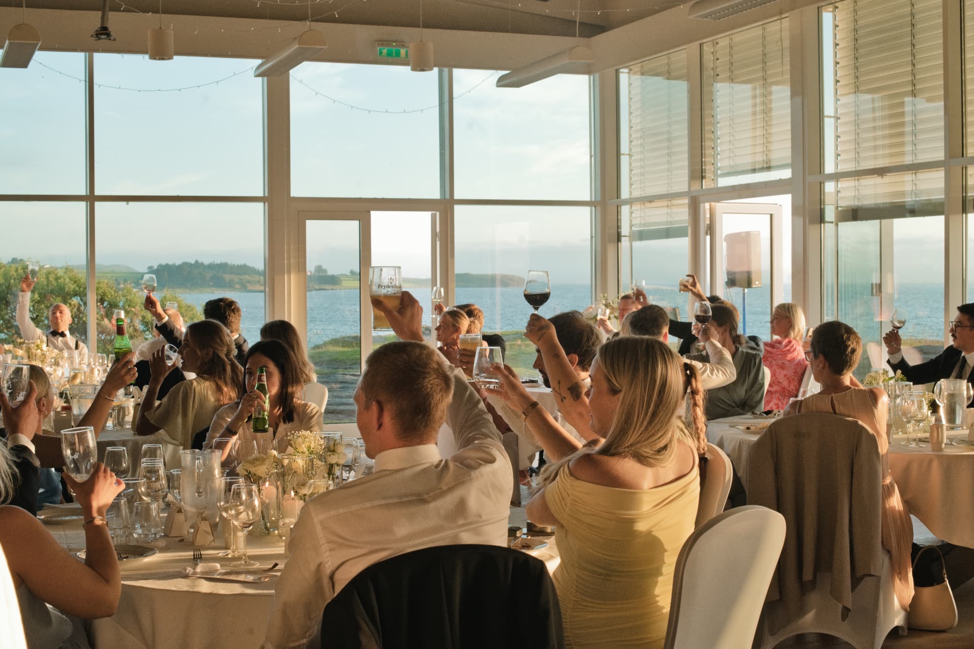 Guests raising a toast in the seaside reception room
