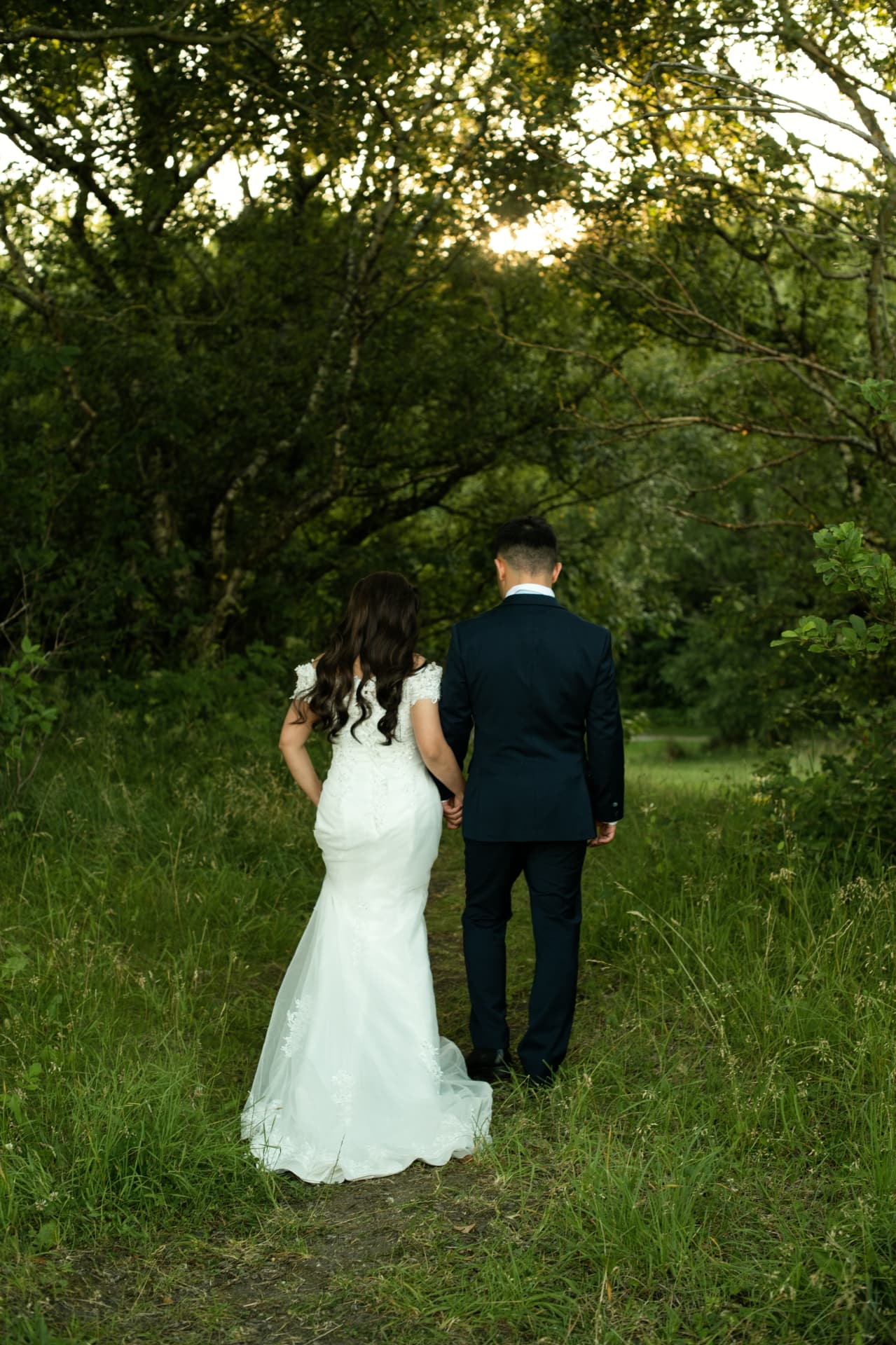 Couple walking hand in hand through the trees