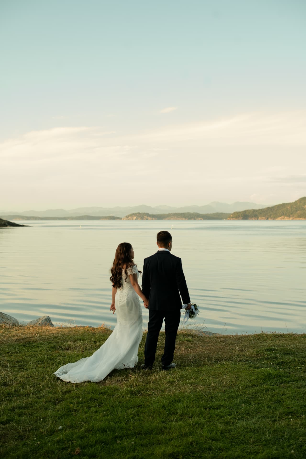 Couple holding hands looking out over the fjord