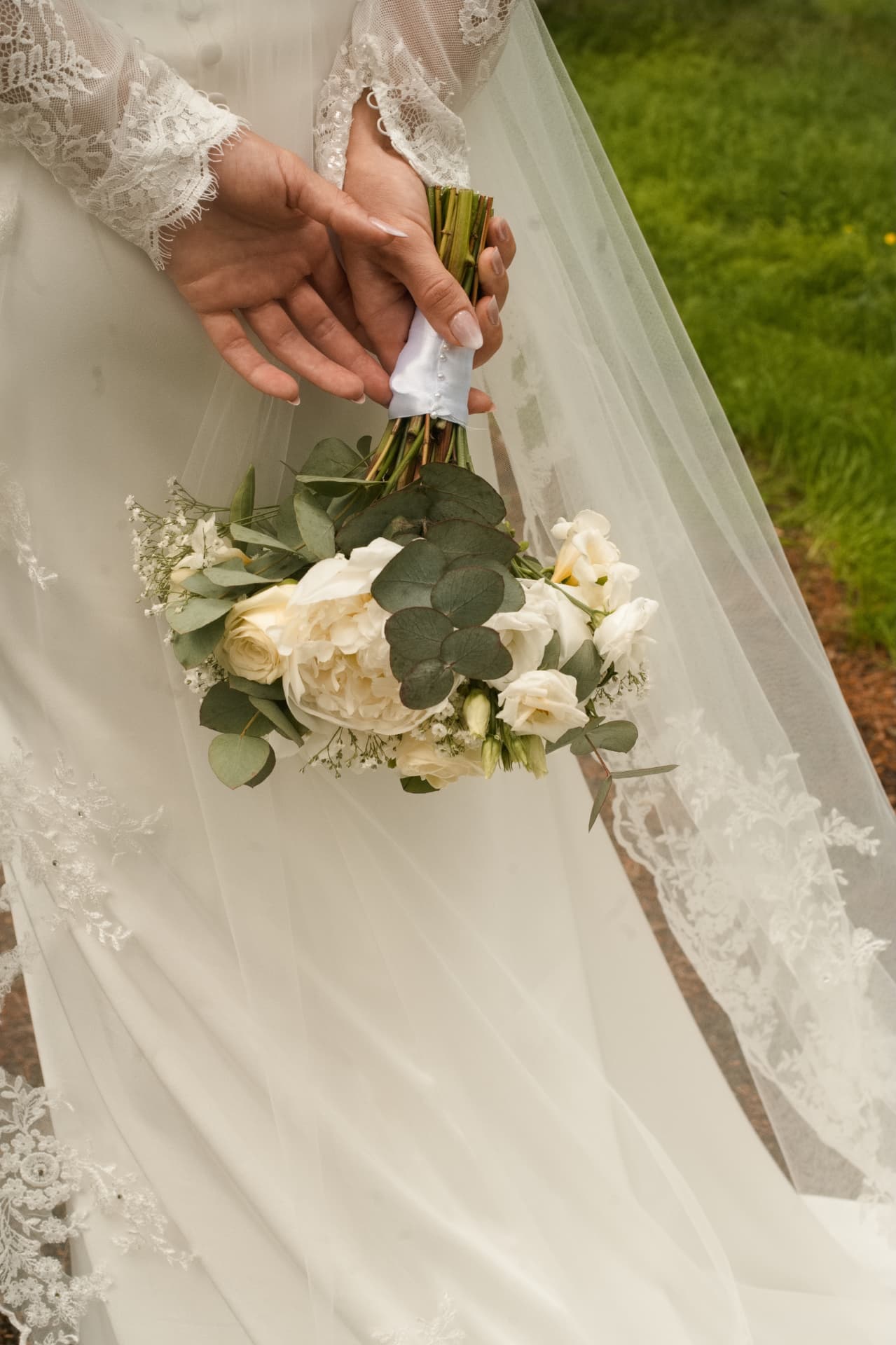 Detail of the bride's bouquet and lace veil