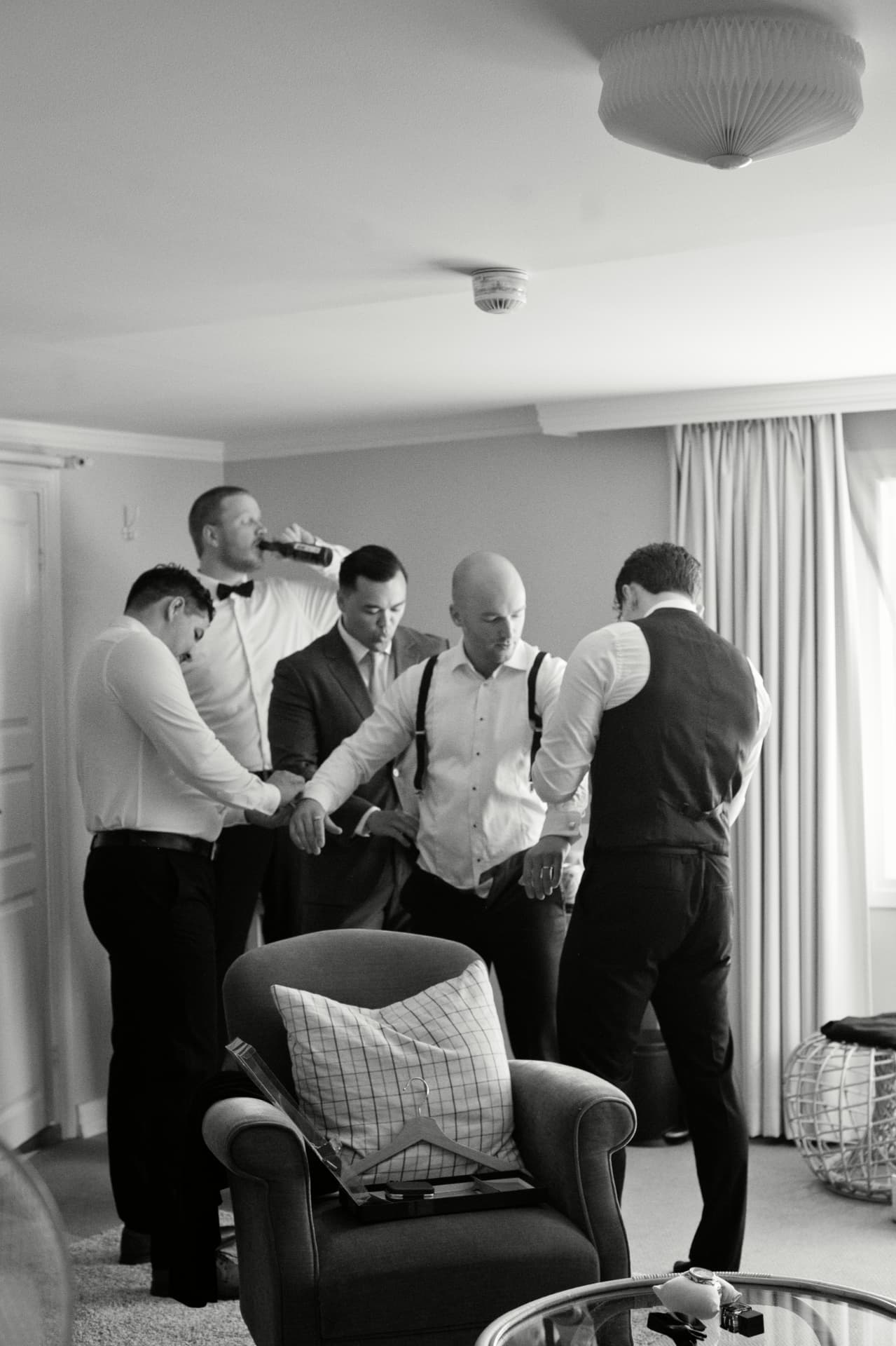 Groomsmen helping the groom dress before the ceremony